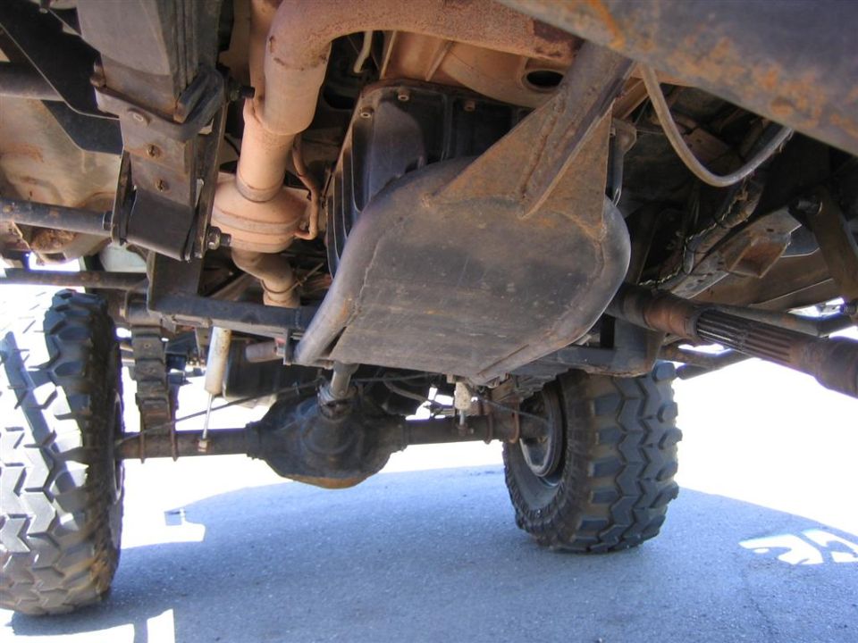 Undercarriage view of a 4x4 with large tires and visible drivetrain components