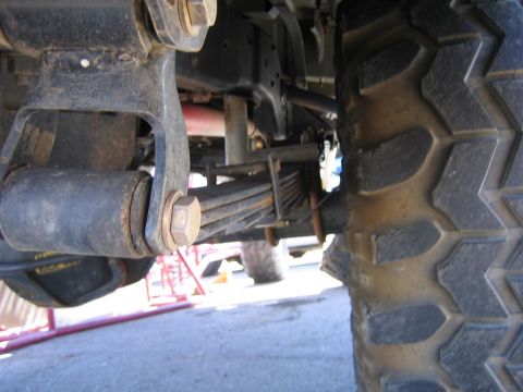 1994 Ford Bronco - Close-up view of the rear leaf spring suspension and tire of a truck, with "SUPERMOTORS.NET" visible in the lower right corner.
