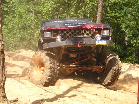 1996 Ford Bronco - Off-road truck navigating a challenging rocky terrain with visible text on the windshield.
