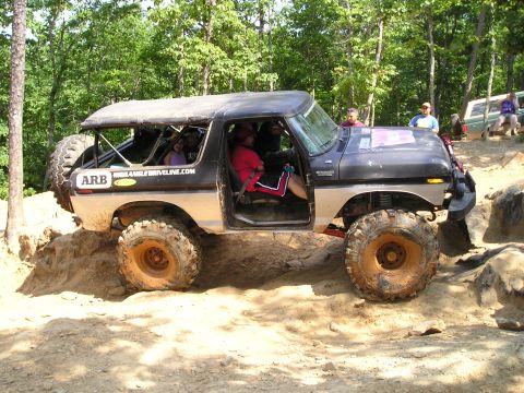 1996 Ford Bronco - This modified Ford Bronco navigates a rocky trail with several passengers inside.