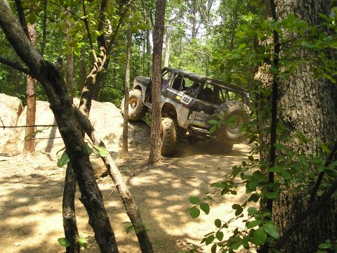 1996 Ford Bronco - This 1996 Ford Bronco navigates a challenging rocky incline on a wooded trail.