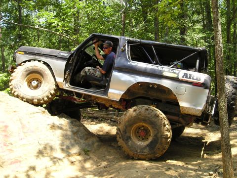 1996 Ford Bronco - This heavily modified SUV navigates a challenging off-road trail with steep inclines and rocky terrain.