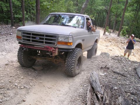 1996 Ford Bronco - This lifted 1995 Ford F-150 navigates a challenging off-road course with a driver and passenger visible.