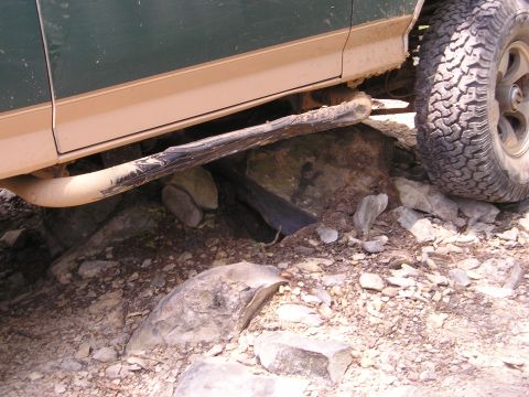 1996 Ford Bronco - A 1996 Ford Bronco navigates a rocky trail, with its side and undercarriage clearly visible.