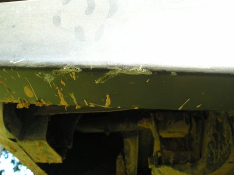 1996 Ford Bronco - Close-up view of the undercarriage of a vehicle, showing mud and damage.