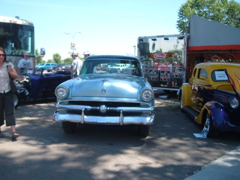 1994 Ford Bronco - A classic light blue Ford sedan is parked at an outdoor event with other vintage vehicles.