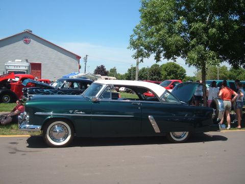 1994 Ford Bronco - A classic 1955 Ford Fairlane Crown Victoria is displayed at an outdoor car show.
