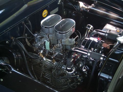 1994 Ford Bronco - A close-up view of a car's engine compartment, highlighting its dual carburetors and polished components.