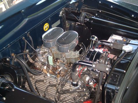 1994 Ford Bronco - Close-up of a V8 engine bay dual carburetors and a distinctive Moon Eyes decal.