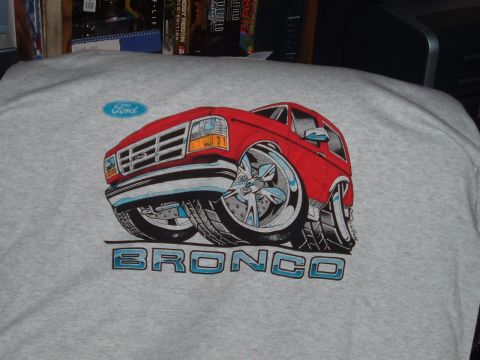 1994 Ford Bronco - A graphic t-shirt displays a stylized red Ford Bronco with large chrome wheels and the word BRONCO printed underneath.