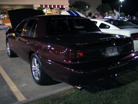 2000 Ford Crown Victoria - This dark red sedan, identified by its 'Marauder' badge, is shown from the rear with its hood open.