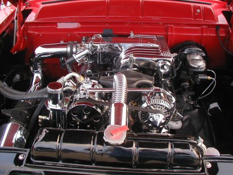 2000 Ford Crown Victoria - Close-up of a highly polished engine bay with chrome accents and red painted surfaces.