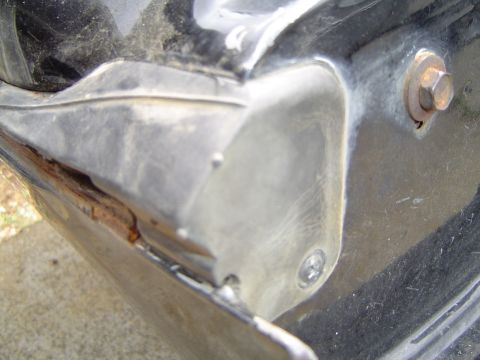 1989 Ford Bronco - Detail of a worn tailgate seal with visible rust and a metal mounting bracket.