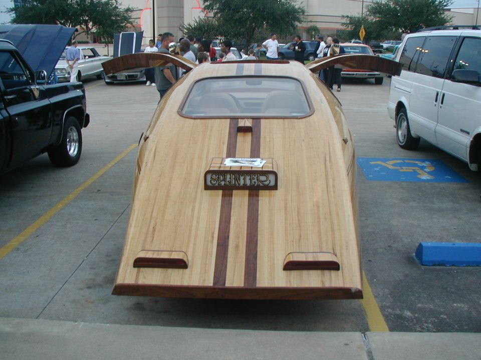 Car with wood body, "SPLINTER" on back. Other cars and a van are parked nearby