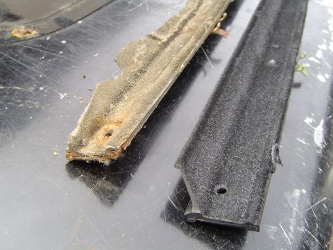 1989 Ford Bronco - Comparison of a worn, rusted tailgate window seal and a new black replacement seal.