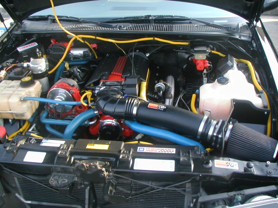 Engine bay with K&N air intake and red accents on engine components