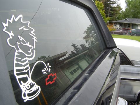 1989 Ford Bronco - Sticker art and Chevrolet emblem visible on the side window of a vehicle.