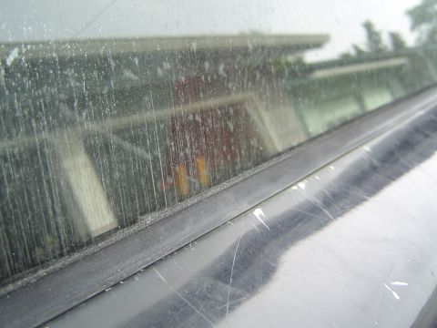 1989 Ford Bronco - A close-up view of a vehicle's window seal, showing dirt and scratches on the exterior.