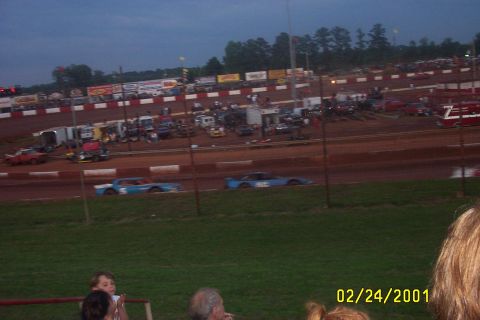 1979 Ford F-150 - Dirt track racing event with multiple cars on the track and spectators in the stands.