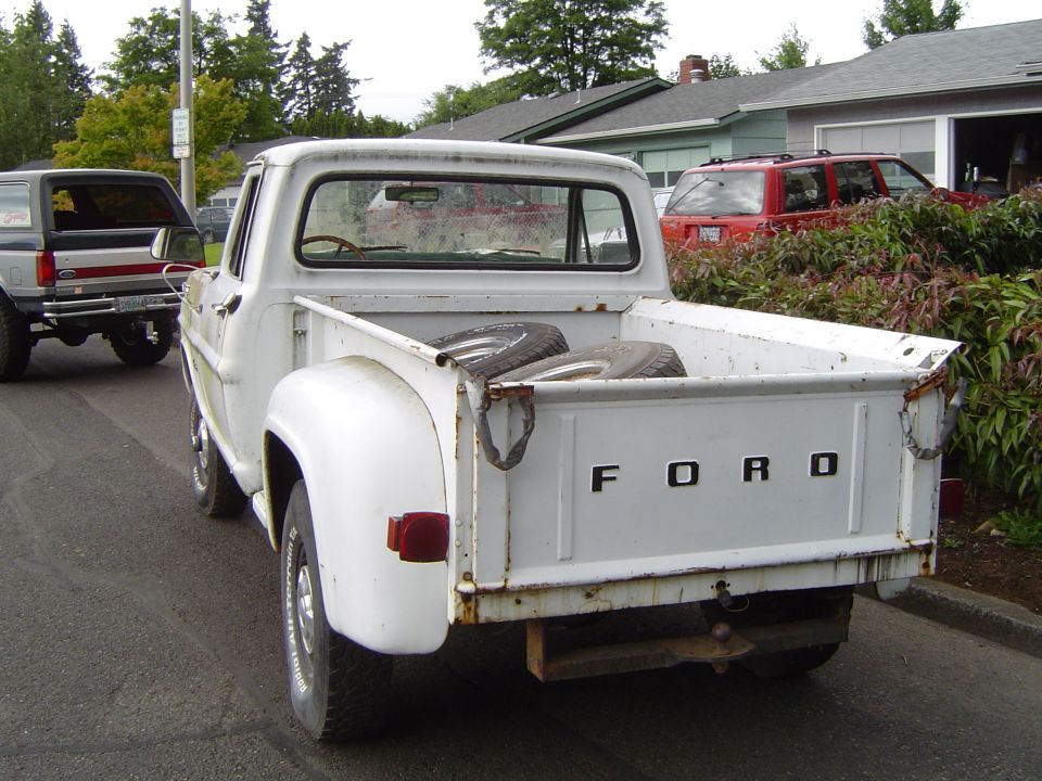 Rear view of white 1972 Ford F-100 pickup truck with spare tires in bed