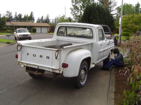 1972 Ford F-100 - White 1972 Ford F-100 pickup truck with 'FORD' on tailgate, parked on a residential street.