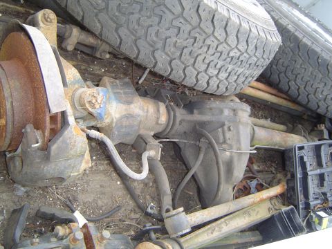 1972 Ford F-100 - Close-up view of a vehicle's rear axle assembly, showing brake components and a spare tire.