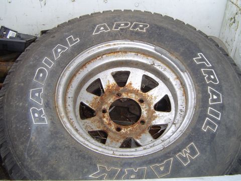 1972 Ford F-100 - A close-up view of a tire and rim, showing white lettering and significant rust on the wheel.