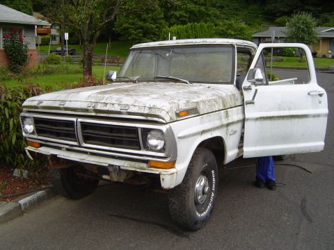 1972 Ford F-100 - A weathered white Ford F-100 truck sits parked on a residential street with its driver's door ajar.