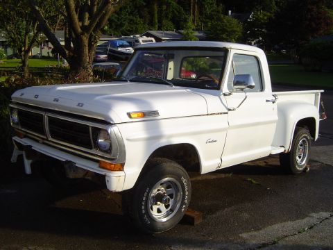 1972 Ford F-100 - White 1970 Ford F-100 Custom pickup truck parked on asphalt with trees and houses in the background.