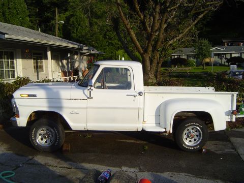1972 Ford F-100 - This white pickup truck is parked in a driveway next to a house and a large tree.