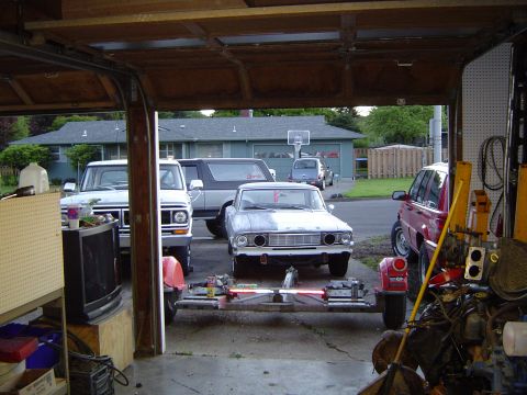 1972 Ford F-100 - A light blue 1964 Ford Falcon with a contrasting white hood is parked in a garage, alongside other vehicles.