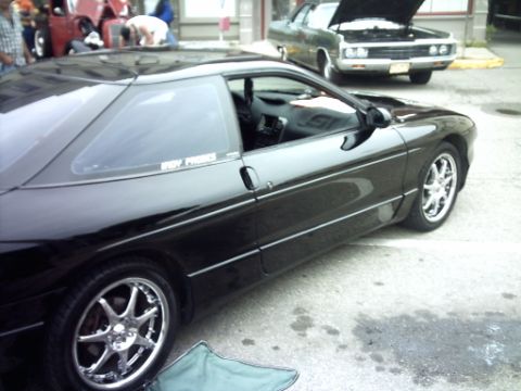 1995 Ford Probe - A black sports coupe is parked on a street, with another car in the background.