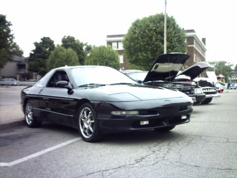 1995 Ford Probe - A black 1995 Ford Probe is parked in a lot, with other vehicles visible behind it.