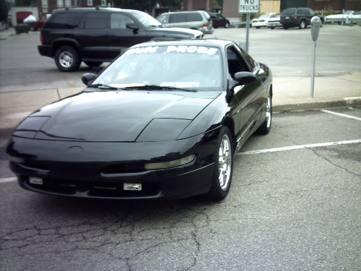 Black 1995 Ford Probe parked in a lot, with a black SUV behind it