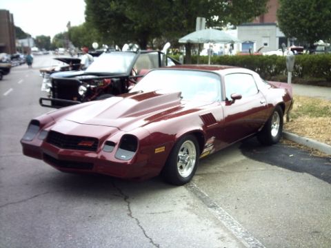 1995 Ford Probe - A maroon Chevrolet Camaro is parked on the street, with another vehicle visible behind it.