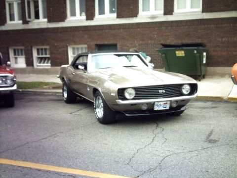 1995 Ford Probe - A classic 1969 Camaro SS convertible is parked on a street in front of a brick building.