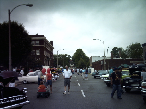 Street scene with cars and people, "SUPERMOTORS" text visible