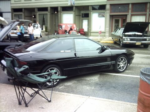 1995 Ford Probe - A black 1995 Ford Probe is parked on the street, with another vehicle visible behind it.