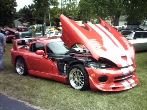 1995 Ford Probe - A red sports car with its hood open is displayed outdoors, with other vehicles visible in the background.