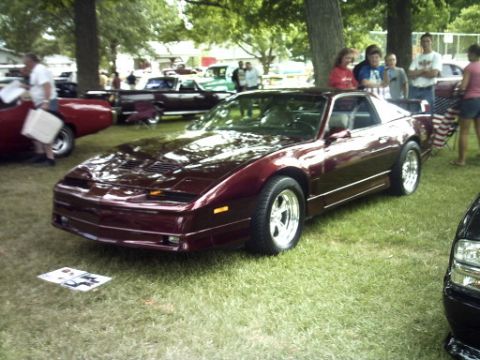 1995 Ford Probe - Maroon 1980s Pontiac Firebird Trans Am at an outdoor car show.