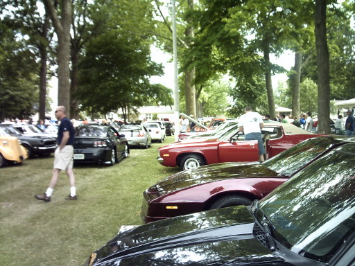 Black 1995 Ford Probe parked on grass at an outdoor car show
