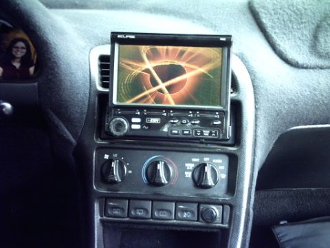 1995 Ford Probe - Dashboard view of a car interior, an aftermarket stereo and climate controls.