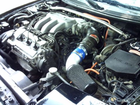 1995 Ford Probe - Close-up view of a car's engine compartment, showing various hoses, wires, and components.