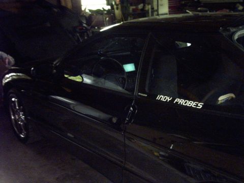 1995 Ford Probe - A black car with its hood open and a sticker on the side is shown from a three-quarter front angle.