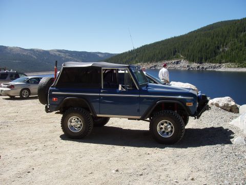 1979 Ford Bronco - 1979 Ford Bronco parked near a lake with mountains in the background.