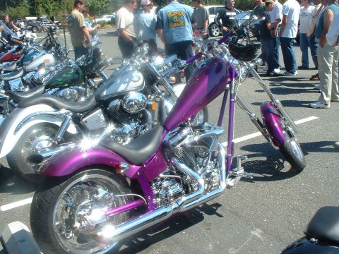 1999 Ford Crown Victoria - A group of motorcycles are displayed at an outdoor event, with a custom chopper in the foreground.