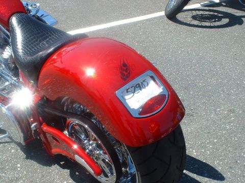 1999 Ford Crown Victoria - A close-up view of a red motorcycle's rear fender and license plate is visible, with another vehicle's wheel in the background.