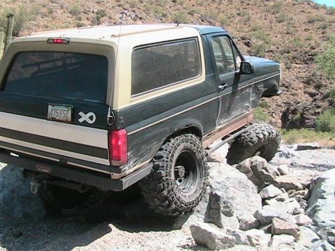 1994 Ford Bronco - This Ford Bronco is navigating a rocky trail in a desert environment.