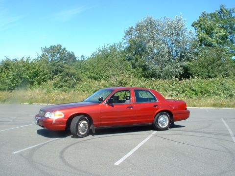 1999 Ford Crown Victoria - A red 1998 Ford Crown Victoria sedan is shown from the front three-quarter view in a parking lot.