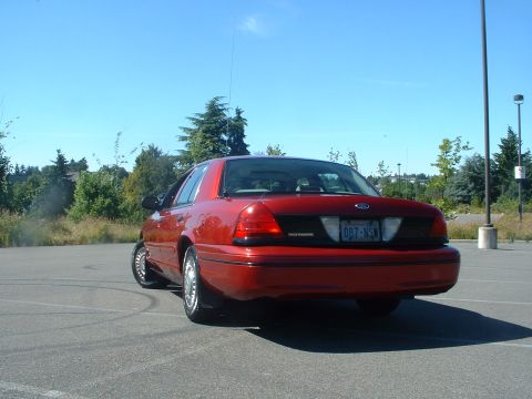 1999 Ford Crown Victoria - Rear view of a red 1999 Ford Crown Victoria, identified by its distinct body style and badging.